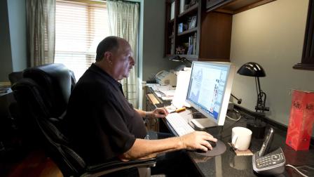 In this Wednesday, Oct. 9, 2013 photo, graphic designer Tom Sadowski, 65, who delayed his retirement, works from home in Sterling, Va.