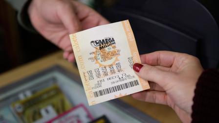 A woman purchases a Mega Millions lottery ticket at a Financial District liquor store Thursday, Dec. 12, 2013, in San Francisco.