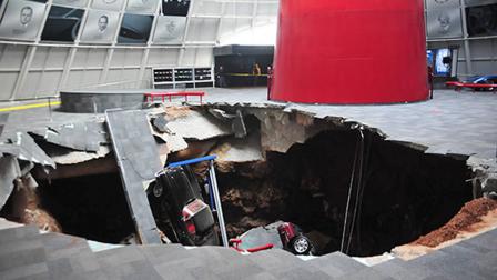 In this image provided by the National Corvette Museum shows several cars that collapsed into a sinkhole Wednesday, Feb. 12, 2014, in Bowling Green, Ky.