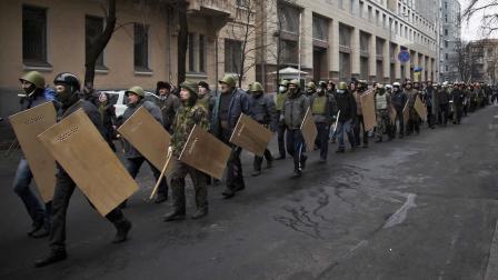 Protesters with shields and sticks move towards the parliament building in central Kiev, Ukraine, Saturday, Feb. 22, 2014