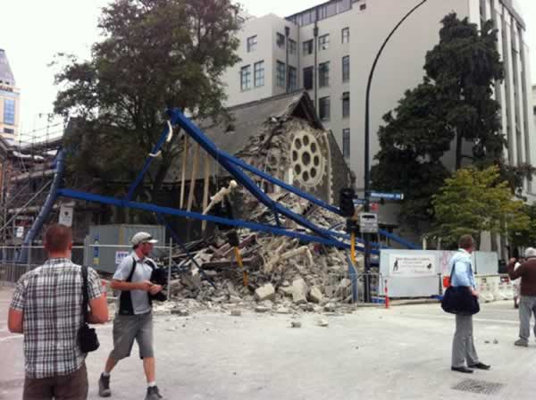 People look at a damaged church after a powerful...