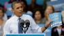 President Barack Obama holds up a copy of his jobs plans while speaking to supporters during a campaign stop at The Mississippi Valley Fairgrounds, Wednesday, Oct. 24, 2012, in Davenport, Iowa.