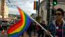 Person waving rainbow flag at march in San Franciscos Castro District