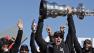 Oracle Team USA skipper Jimmy Spithill holds up the Auld Mug as they celebrate in the podium after winning the Americas Cup sailing event over Emirates Team New Zealand on Wednesday, Sept. 25, 2013, in San Francisco. (AP Photo/Marcio Jose Sanchez)