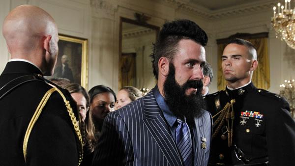 San Francisco Giants pitcher Brian Wilson, center, walks past Marine honor guards at the conclusion of a ceremony hosted by President Barack Obama