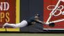 Oakland Athletics center fielder Coco Crisp dives for a double hit by Cincinnati Reds Shin-Soo Choo in the fifth inning of a baseball game.