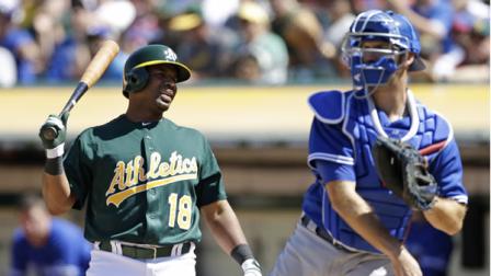 Oakland Athletics Alberto Callaspo, left, reacts after being called out on strikes as Toronto Blue Jays catcher J.P. Arencibia, right, throws the ball back to pitcher Casey Janssen during the ninth inning of their baseball game