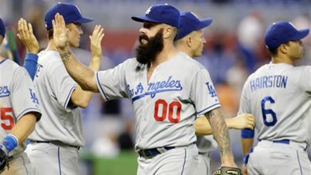 Los Angeles Dodgers relief pitcher Brian Wilson (00) high-fives his teammates after the Dodgers defeated the Miami Marlins 6-0 during a baseball game, Thursday, Aug. 22, 2013 in Miami. (AP Photo/Lynne Sladky)
