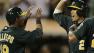 Oakland Athletics Kurt Suzuki, center, is congratulated by Alberto Callaspo (18) and Chris Young (25) after Suzuki hit a three-run home run off Tampa Bay Rays David Price in the fifth inning