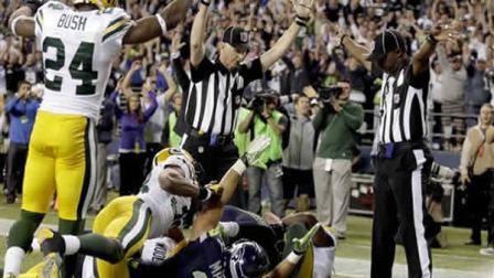 Officials signal a touchdown by Seattle Seahawks wide receiver Golden Tate, obscured, on the last play of an NFL football game against the Green Bay Packers, Monday, Sept. 24, 2012, in Seattle. The Seahawks won 14-12.
