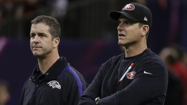 San Francisco 49ers head coach Jim Harbaugh, right, and Baltimore Ravens head coach John Harbaugh look on during practice before the NFL Super Bowl XLVII.