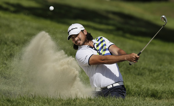 Jason Day, of Australia, hits out of a bunker on...