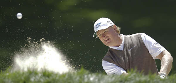 Ernie Els, of South Africa, hits out of a bunker...