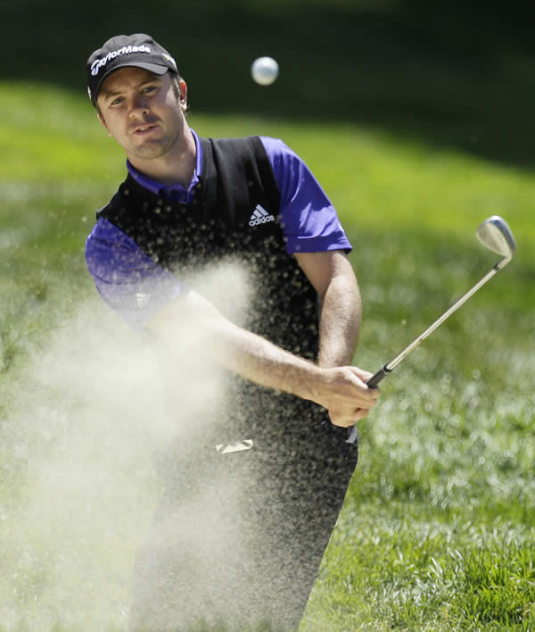 Martin Laird, of Scotland, hits out of a bunker...