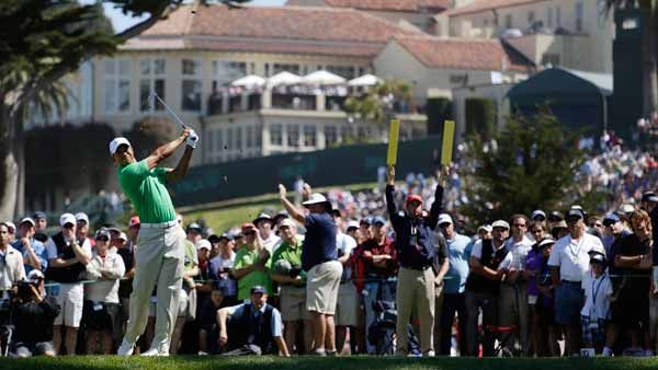 Tiger Woods hits a drive on the fourth hole...