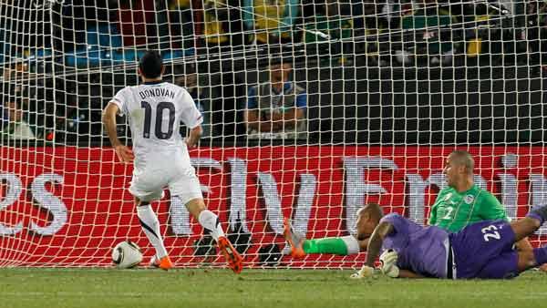 United States' Landon Donovan, left, scores a goal past Algeria goalkeeper Rais M'Bolhi, front right, and Algeria's Madjid Bougherra, back right, during the World Cup group C soccer match between the United States and Algeria.