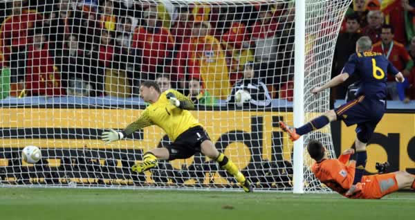 Spain's Andres Iniesta, right, scores a goal...