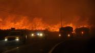 Firefighters retreat quickly as flames approach Elizabeth Lake Road in Leona Valley as a fast moving wildfire  nears Palmdale, Calif. on Thursday, July 29, 2010.