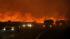 Firefighters retreat quickly as flames approach Elizabeth Lake Road in Leona Valley as a fast moving wildfire  nears Palmdale, Calif. on Thursday, July 29, 2010.