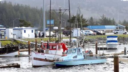 Driven by the force of a tsunami surge, a loose boat slams into another in the boat basin at Crescent City