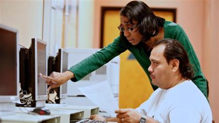 In this photo taken on on Thursday , Feb. 3, 2011, State of California Employment Program Representative, Brigitta Croil, assists job seeker Freddy Gomez, to look for driver job position at the Verdugo Job Center in Glendale, Calif.