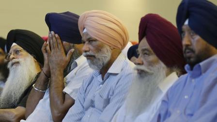 Members of the Sikh Temple of Wisconsin react at a news conference at Oak Creek Centennial church in Oak Creek, Wis. on Monday, Aug. 6, 2012.