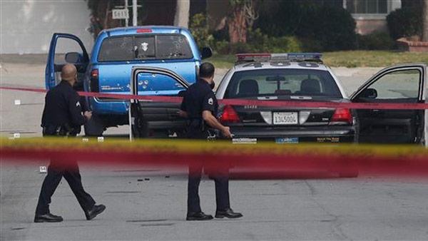 Law enforcement officers look over the scene of an officer involved shooting in Torrance, Calif., Thursday, Feb. 7, 2013. The shooting is believed to related to the manhunt for fired Los Angeles police officer, Christopher Dorner. (AP Photo/Chris Carlson)