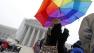Clair Sharpless from Miami cover from the snow with a rainbow umbrella as she wait in line to enter, outside of the U.S. SupremeCourt, in Washington, on Monday March, 25.
