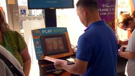 Person buying a lottery ticket at a Powerball machine