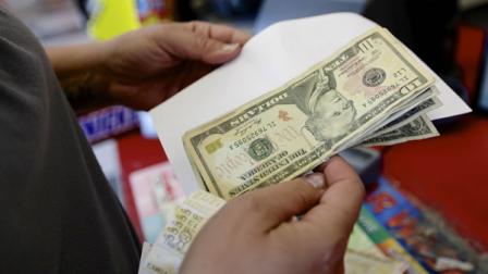 Cathy Munoz of Lincoln goes over her list and has the money to buy Powerball tickets.
