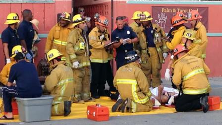 Police and fire officials assist an injured pedestrian at the scene where a car drove through a packed afternoon crowd along the Venice Beach boardwalk in Los Angeles, Saturday, Aug. 3, 2013.