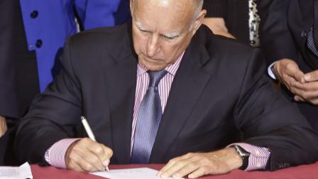California Gov. Jerry Brown signs legislative bill AB639 that will ask voters to repurpose $600 million of existing veterans housing bonds for use in building veteran housing Thursday, Oct. 10, 2013, in San Diego.