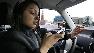 New driver Brandi Eadie, 16, looks down at her cell phone to read a text message as she drives through a rubber-cone course in Seattle.