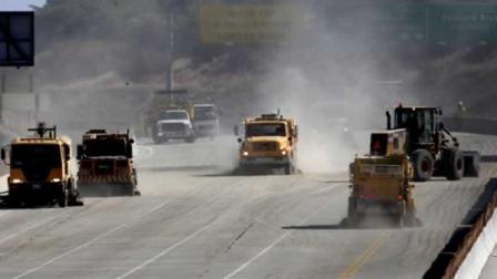 Street sweepers apply the finishing touches as the demolition of two lanes of the Mulholland Drive bridge over Interstate 405 is completed before noon in Los Angeles Sunday, July 17, 2011. The event that many feared would be the Carmageddon of epic traffic jams cruised calmly toward a finish Sunday as bridge work on the Los Angeles roadway was completed 16 hours ahead of schedule and officials reopened a 10-mile stretch of one of the nations busiest freeways. (AP Photo/Reed Saxon)