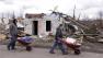 Volunteers look for residents in need of assistance as they attempt to recover possessions from their destroyed homes in Henryville, Ind., Sunday, March 4, 2012.