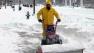 Man clears snow from sidewalk after northeast blizzard