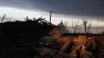 At sunrise Tuesday May 21, 2013, an American flag blows in the wind atop the rubble of a destroyed home in Moore, Okla.