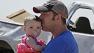 A man carries a child in Oklahoma after a tornado struck and created widespread damage