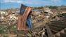 Man holds flag in rubble of tornado in Oklahoma
