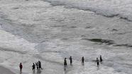People play in the surf in Gulf Shores, Ala., Sunday, Oct. 6, 2013. Forecasters said that Tropical Storm Karen dissipated and was just a low pressure area that will bring heavy rains to the coast