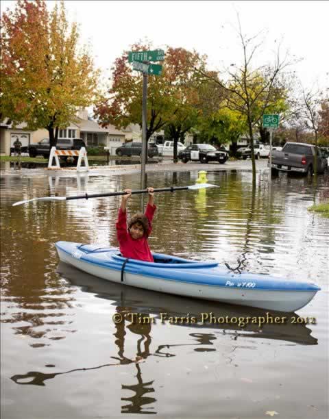 Joshua kayaks in the floodwaters at 5th and...