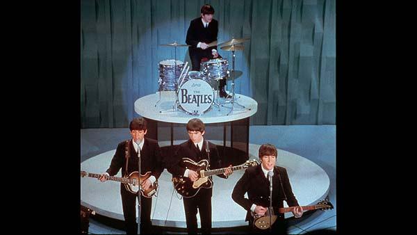 The Beatles perform on the Ed Sullivan Show during the bands first American appearance in New York City, Feb. 9, 1964. From left in front row are, Paul McCartney, George Harrison and John Lennon. Drummer Ringo Starr is at rear. (AP Photo)