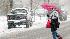 Margie Beckman braces against blowing snow as...