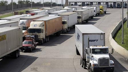 A freight truck, right, breezes through a congested border check point using a Free and Secure Trade Lane, or FAST Lane, in Laredo, Texas, Wednesday, Oct. 14, 2009. The FAST Lane is part of the Customs-Trade Partnership Against Terrorism, or C-TPAT. (AP Photo/Eric Gay)