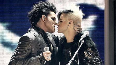 Adam Lambert, left, gets ready to kiss one of the dancers as he performs during the closing act of the 37th Annual American Music Awards on Sunday, Nov. 22, 2009, in Los Angeles. (AP Photo/Matt Sayles)