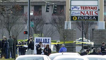 Law enforcement officials gather near the scene where four Lakewood, Wash., police officers were fatally shot while they sat in the Forza Coffee Company, Sunday, Nov. 29, 2009, in Parkland, Wash. (AP Photo/Ted S. Warren)