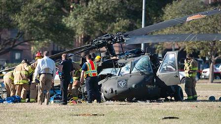 Officials examine a helicopter after it crashed on the campus of Texas A&M University on Monday afternoon, Jan. 12, 2009 in College Station, Texas. (AP Photo/Wade Barker)