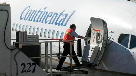 In this Jan. 30, 2009 photo, a food service employee wheels a cart into a Continental Airlines jet at Houstons George Bush Intercontinental Airport. Continental Airlines on Monday, March 15, 2010 announced it is ending free hamburgers, barbecue and sandwich rolls for many of its passengers in favor of a food-for-sale program that mirrors what other carriers are already doing. (AP Photo/Robert Graves)