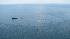 Response boats work to clean up oil where the...
