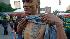 A man holds up his shirt to show a tattoo...